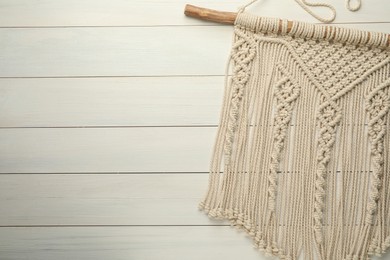 Photo of Stylish beige macrame on white wooden table, top view. Space for text