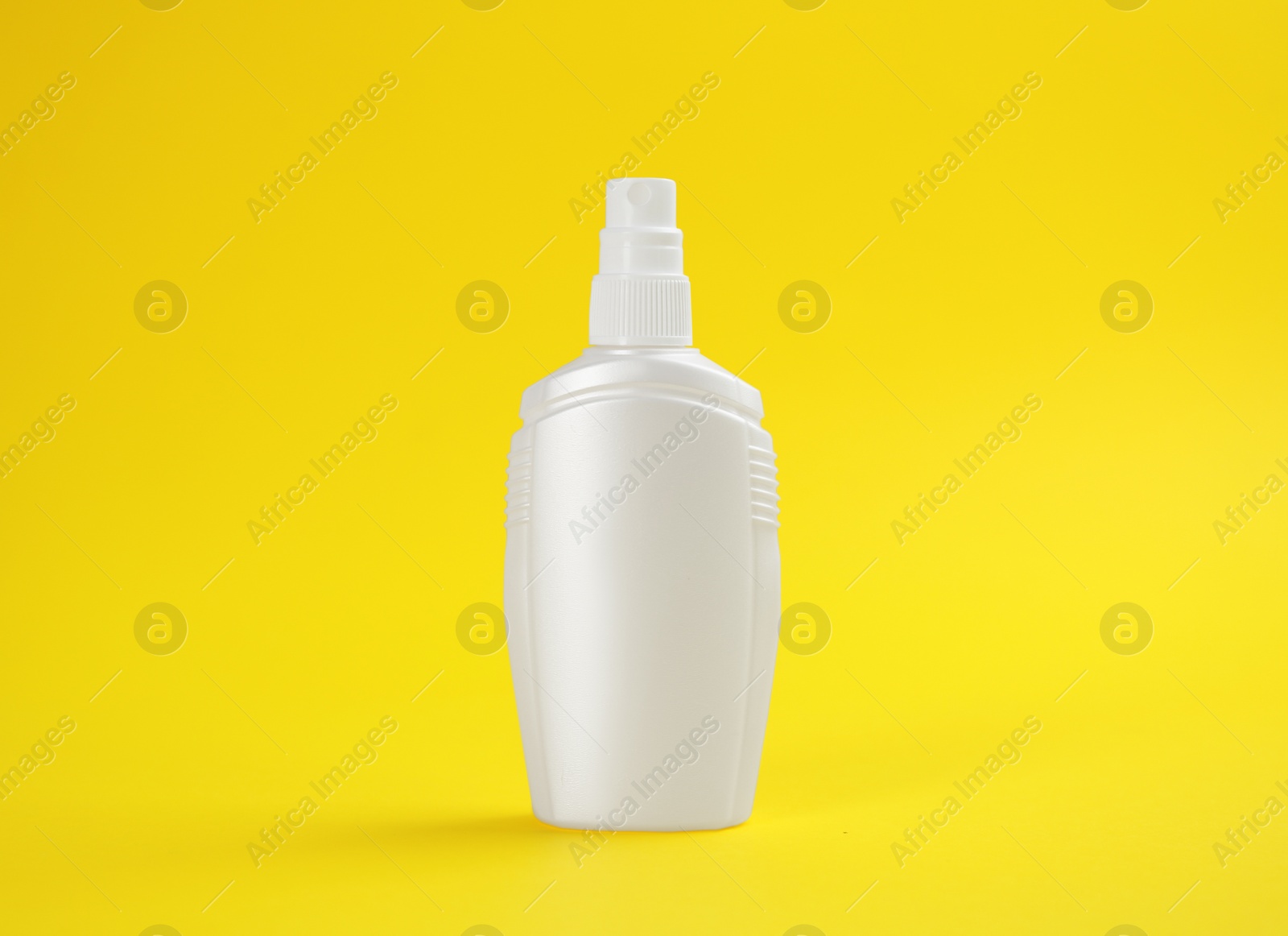 Photo of Bottle with insect repellent spray on yellow background