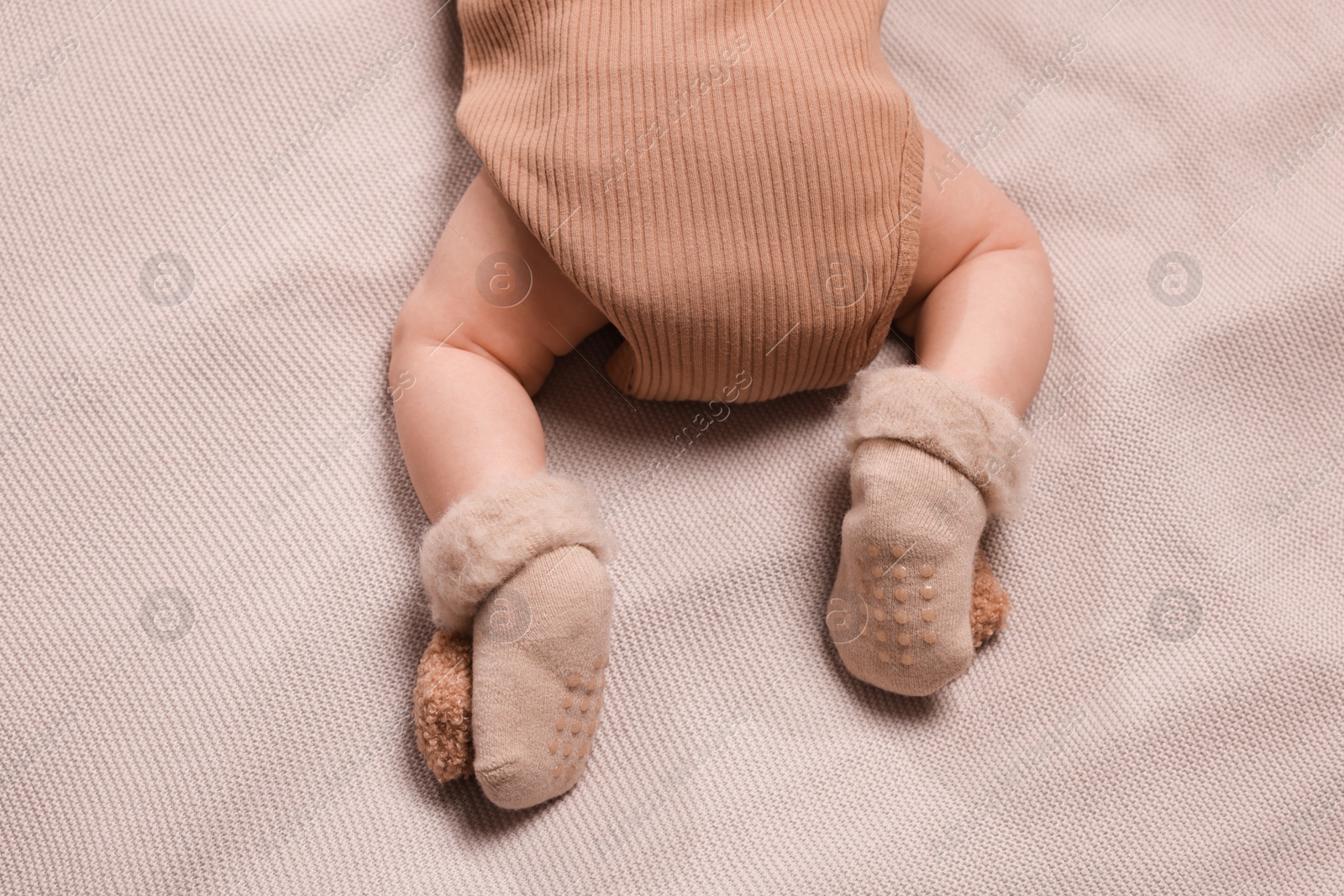 Photo of Newborn baby lying on brown blanket, top view
