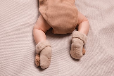 Newborn baby lying on brown blanket, top view