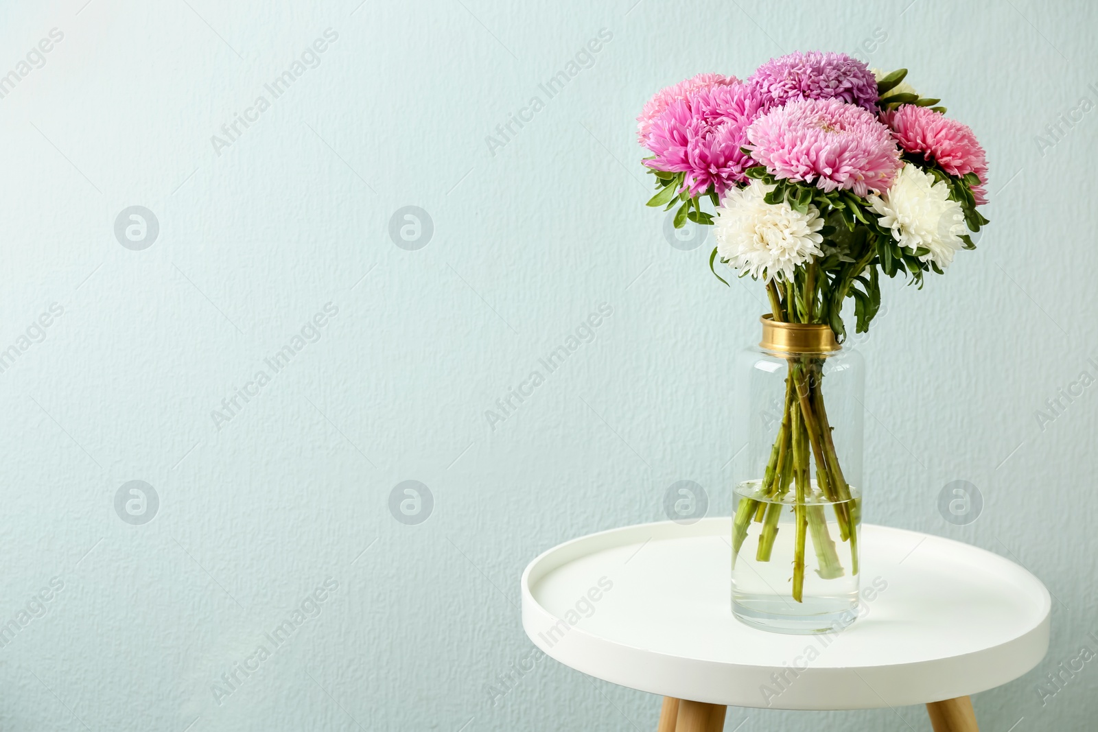 Photo of Bouquet of beautiful asters on table, space for text. Autumn flowers