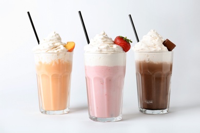 Photo of Glasses with delicious milk shakes on white background