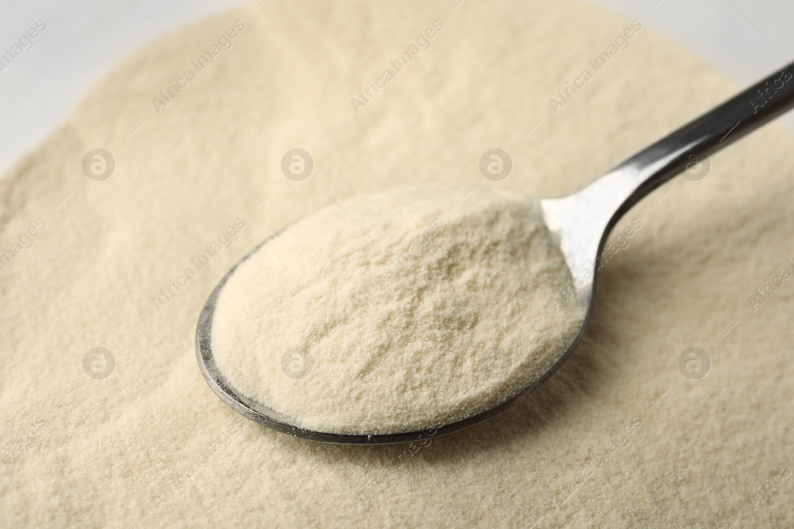 Photo of Organic agar-agar powder and spoon on table, closeup