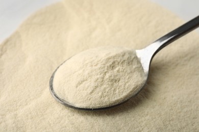 Photo of Organic agar-agar powder and spoon on table, closeup