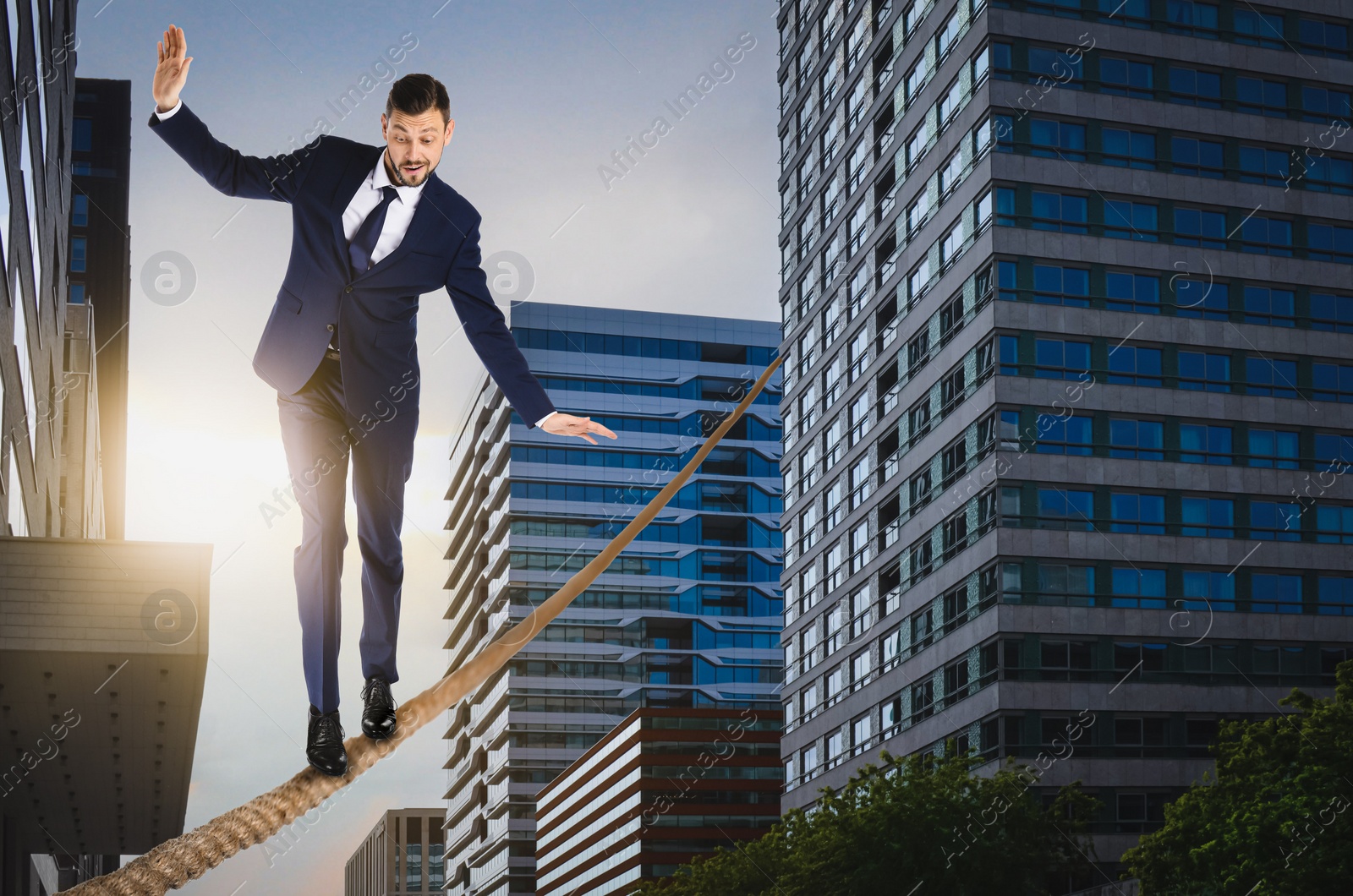 Image of Risks and challenges of entrepreneurship. Businessman balancing on rope in city