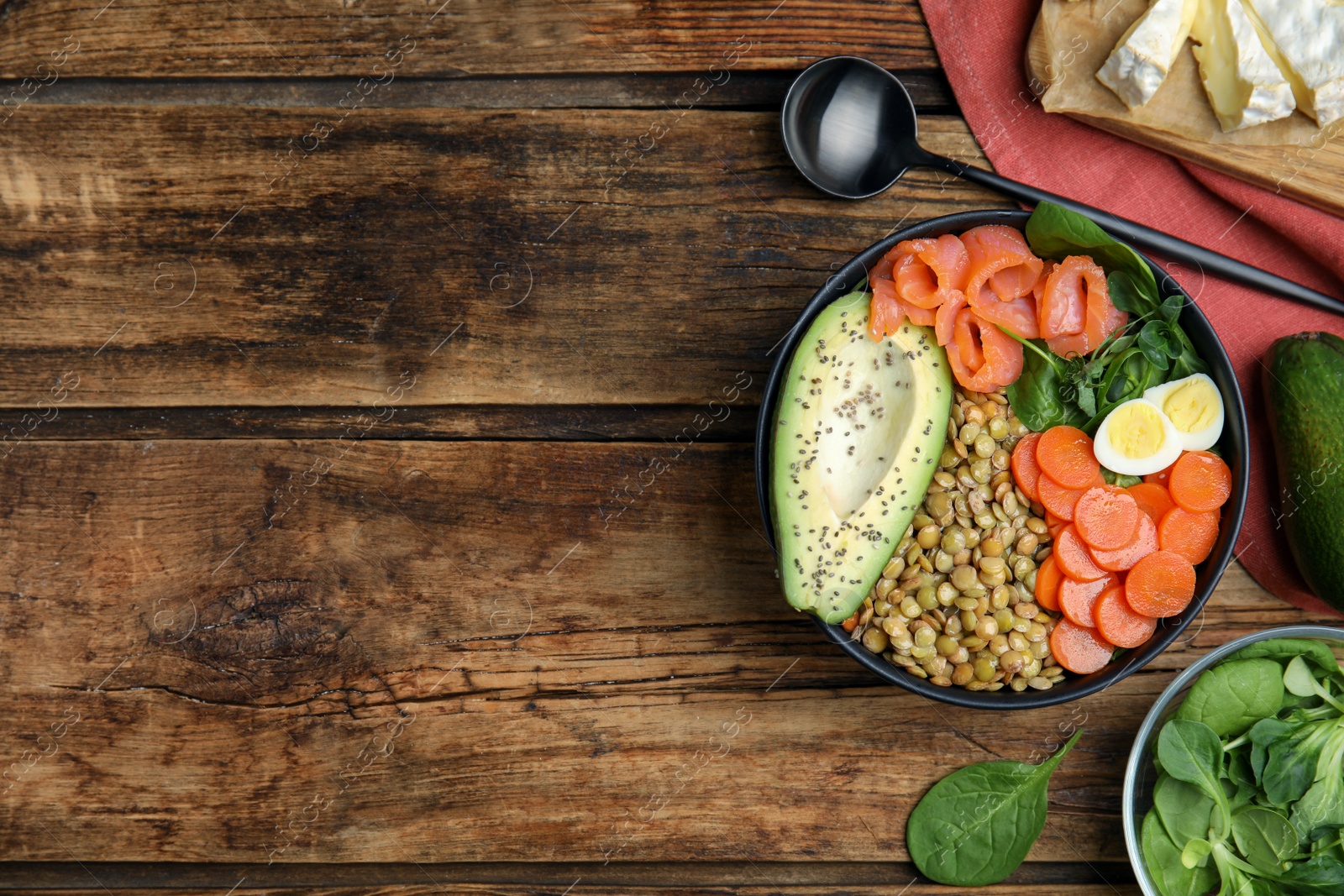 Photo of Delicious lentil bowl with carrot, avocado, egg and salmon on wooden table, flat lay. Space for text