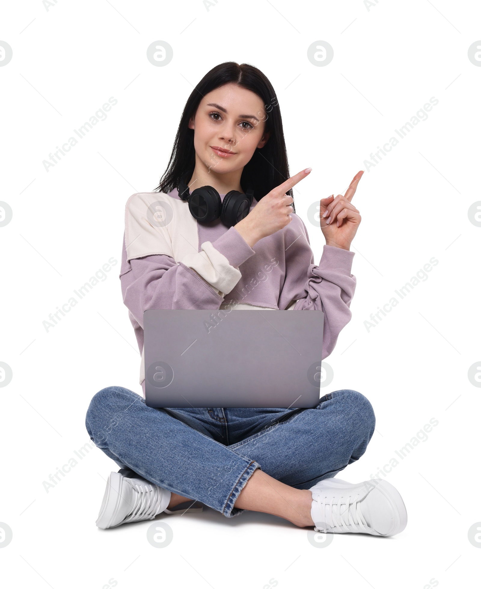 Photo of Student with laptop pointing at something on white background