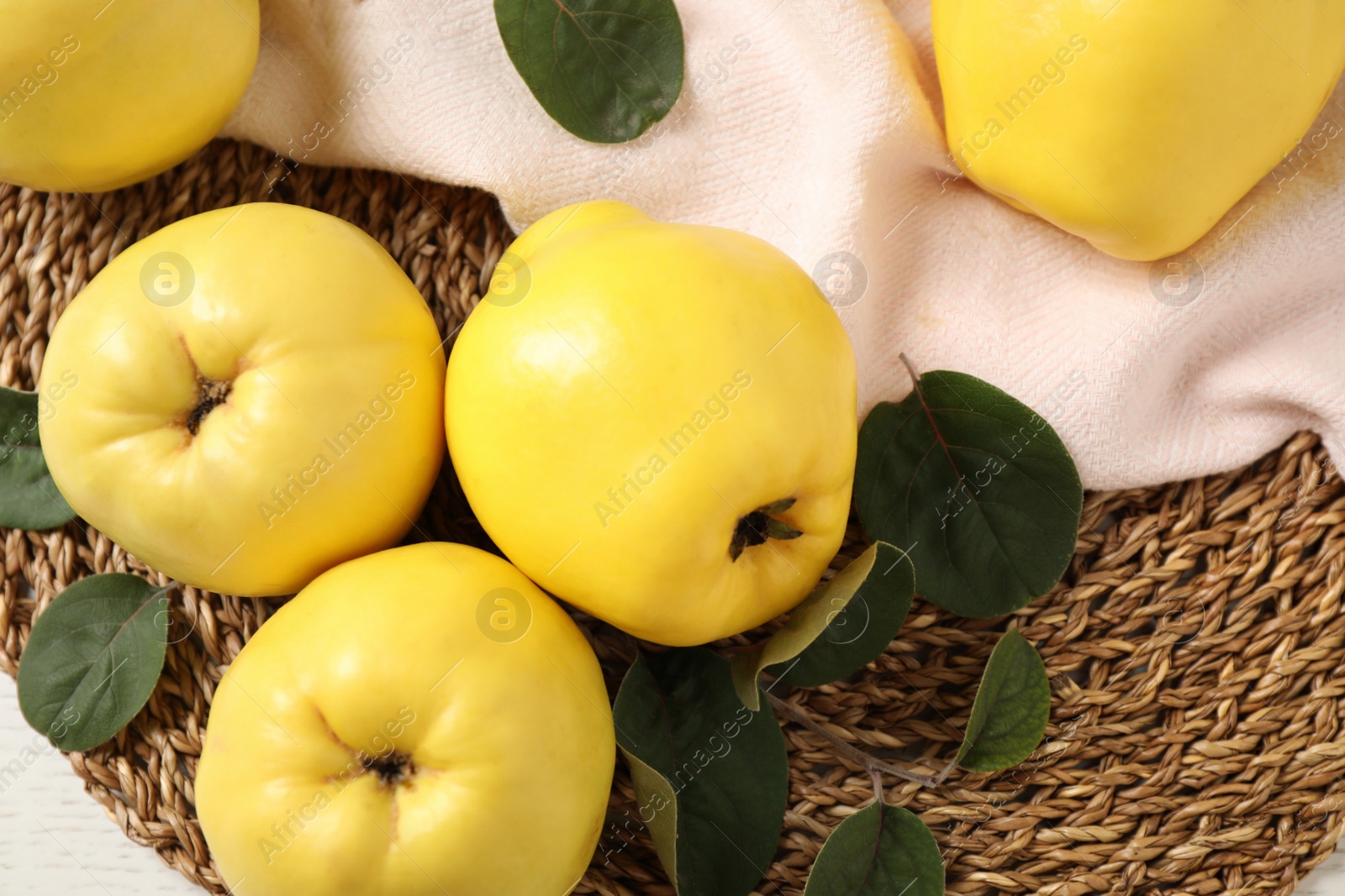 Photo of Fresh ripe organic quinces with leaves on table, flat lay