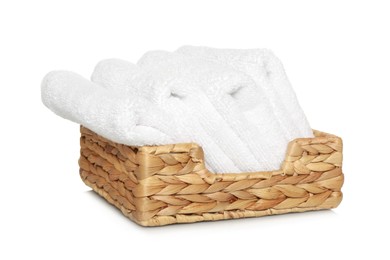 Photo of Wicker basket with folded soft terry towels on white background