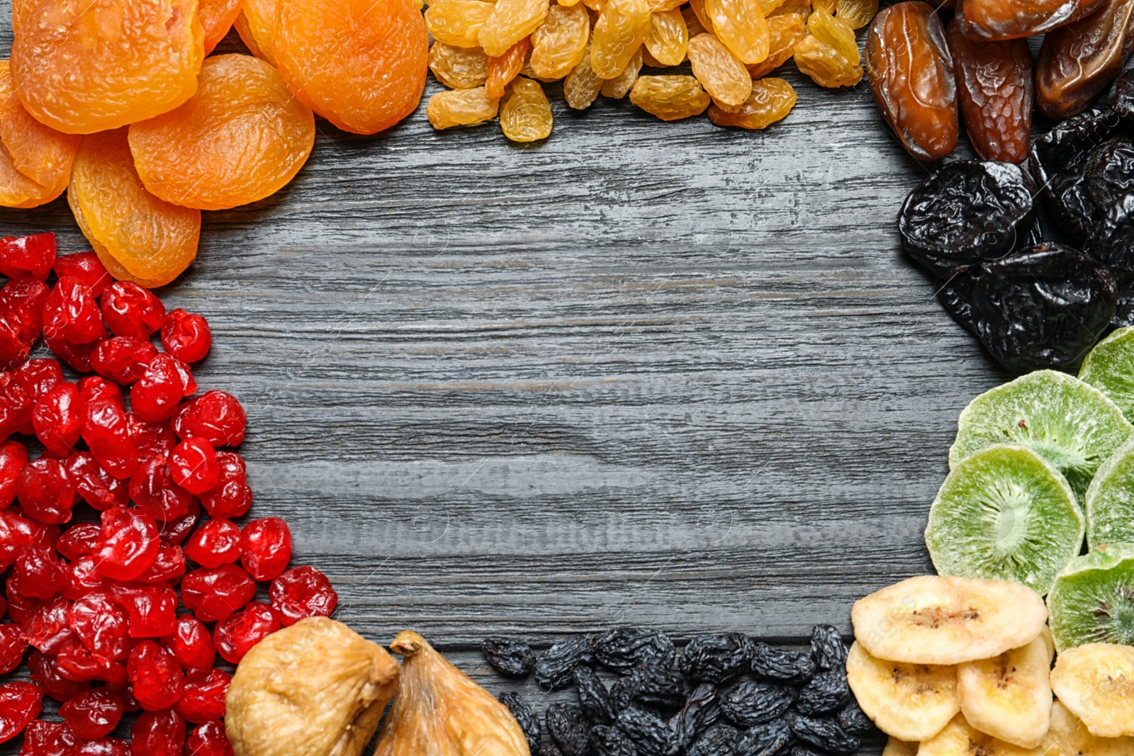 Photo of Frame made of different dried fruits on wooden background, flat lay with space for text. Healthy lifestyle