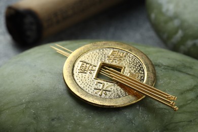 Photo of Acupuncture treatment. Stone with needles and Chinese coin on table, closeup