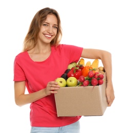 Young woman with box of fresh vegetables on white background