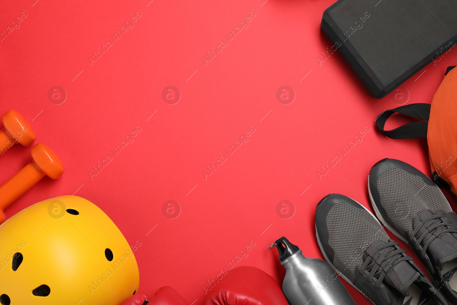 Photo of Frame made of different sports equipment on red background, flat lay. Space for text