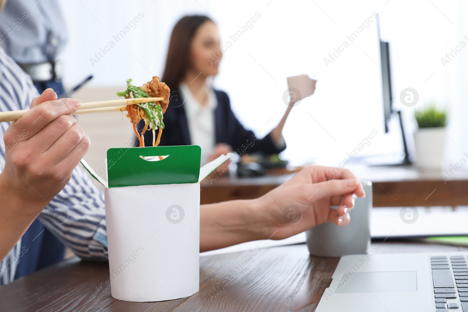 Photo of Office employee having noodles for lunch at workplace, closeup. Food delivery