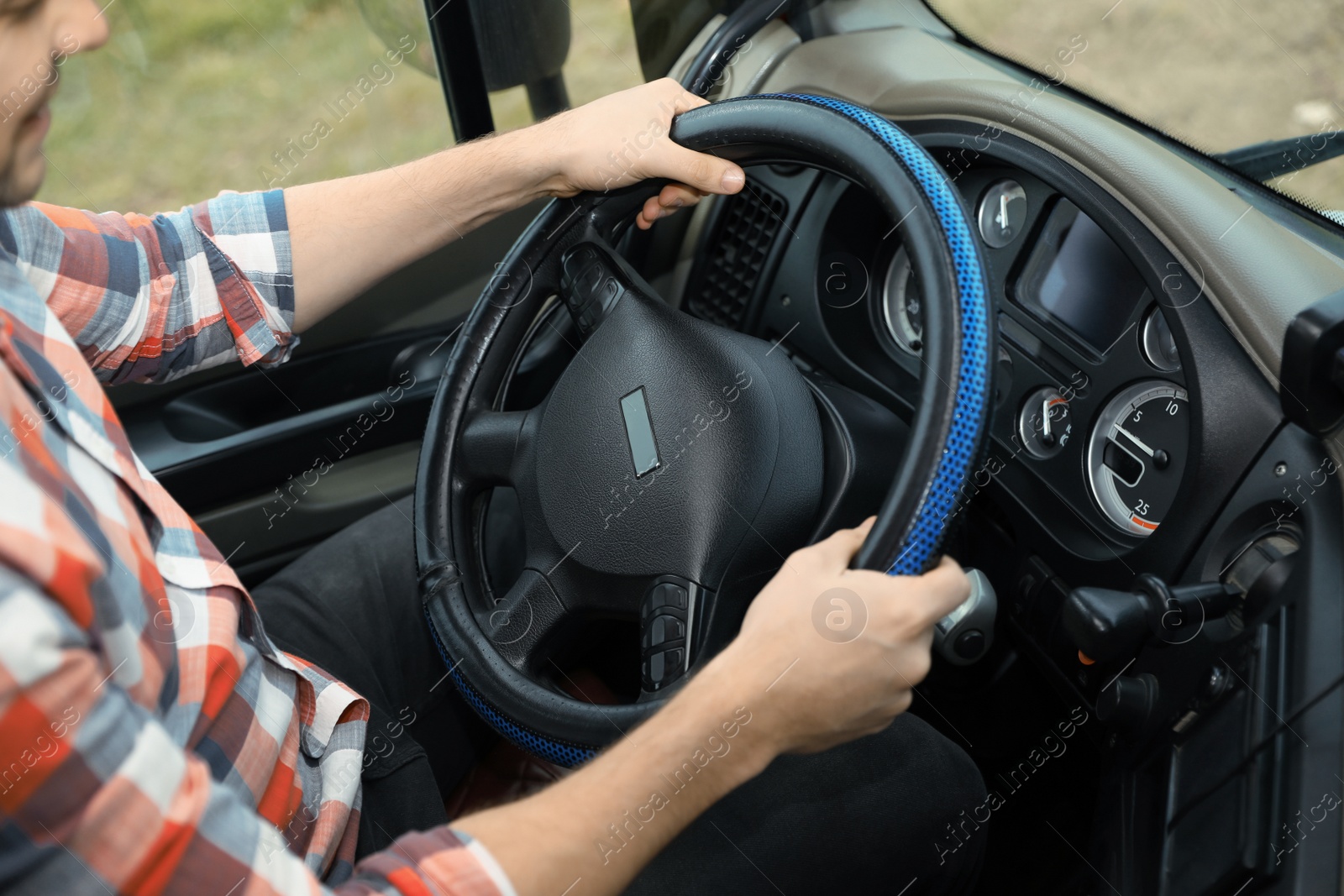 Photo of Mature driver sitting in cab of modern truck, closeup view