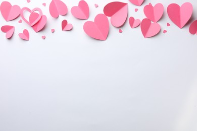 Pink paper hearts on white background, flat lay. Space for text