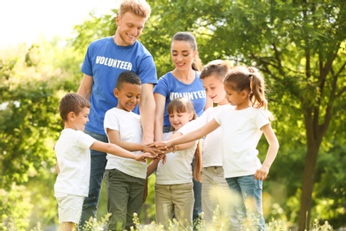 Photo of Group of kids joining hands with volunteers in park