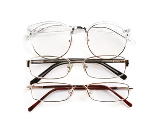 Photo of Different glasses with corrective lenses on white background. Vision problem