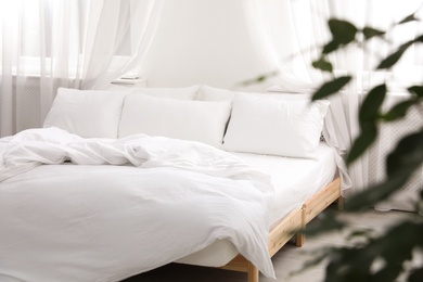 Photo of Comfortable bed with soft pillows in room interior