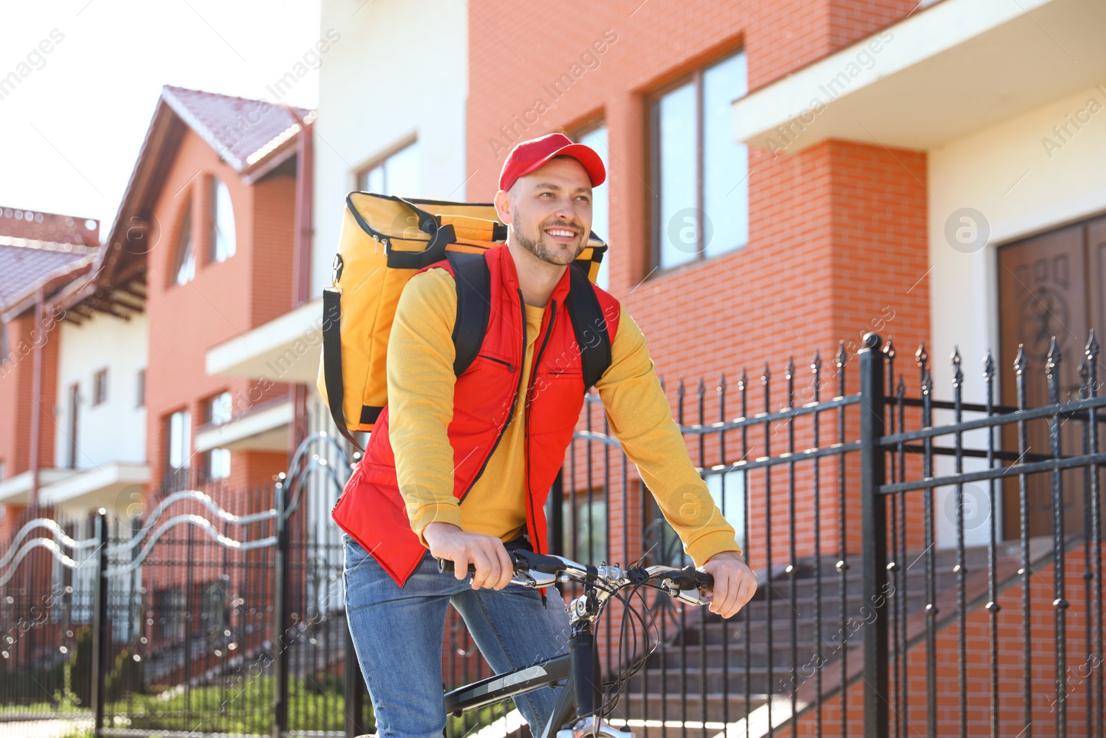 Photo of Male courier on bicycle delivering food in city