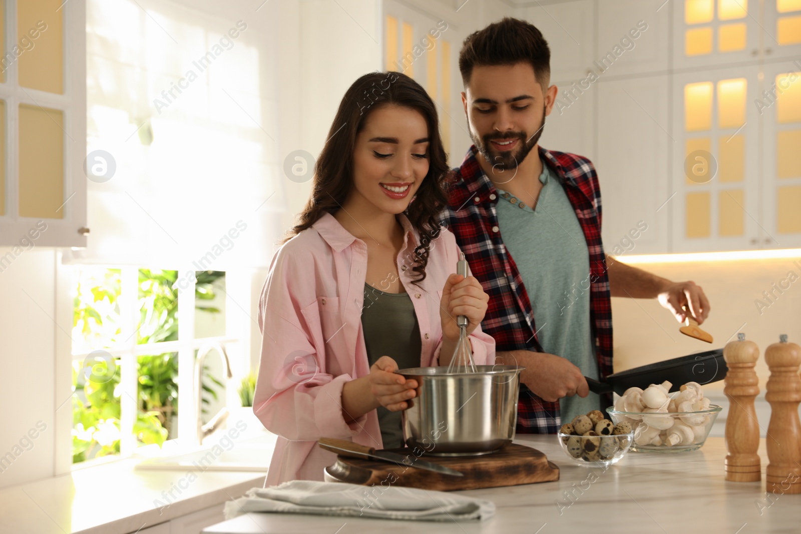 Photo of Lovely young couple cooking together in kitchen