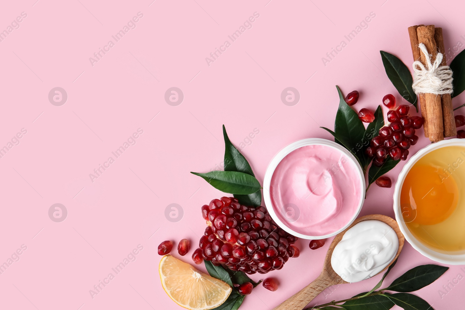 Photo of Flat lay composition with natural homemade mask, pomegranate and ingredients on pink background. Space for text