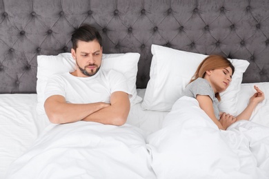 Photo of Couple with relationship problems in bed at home