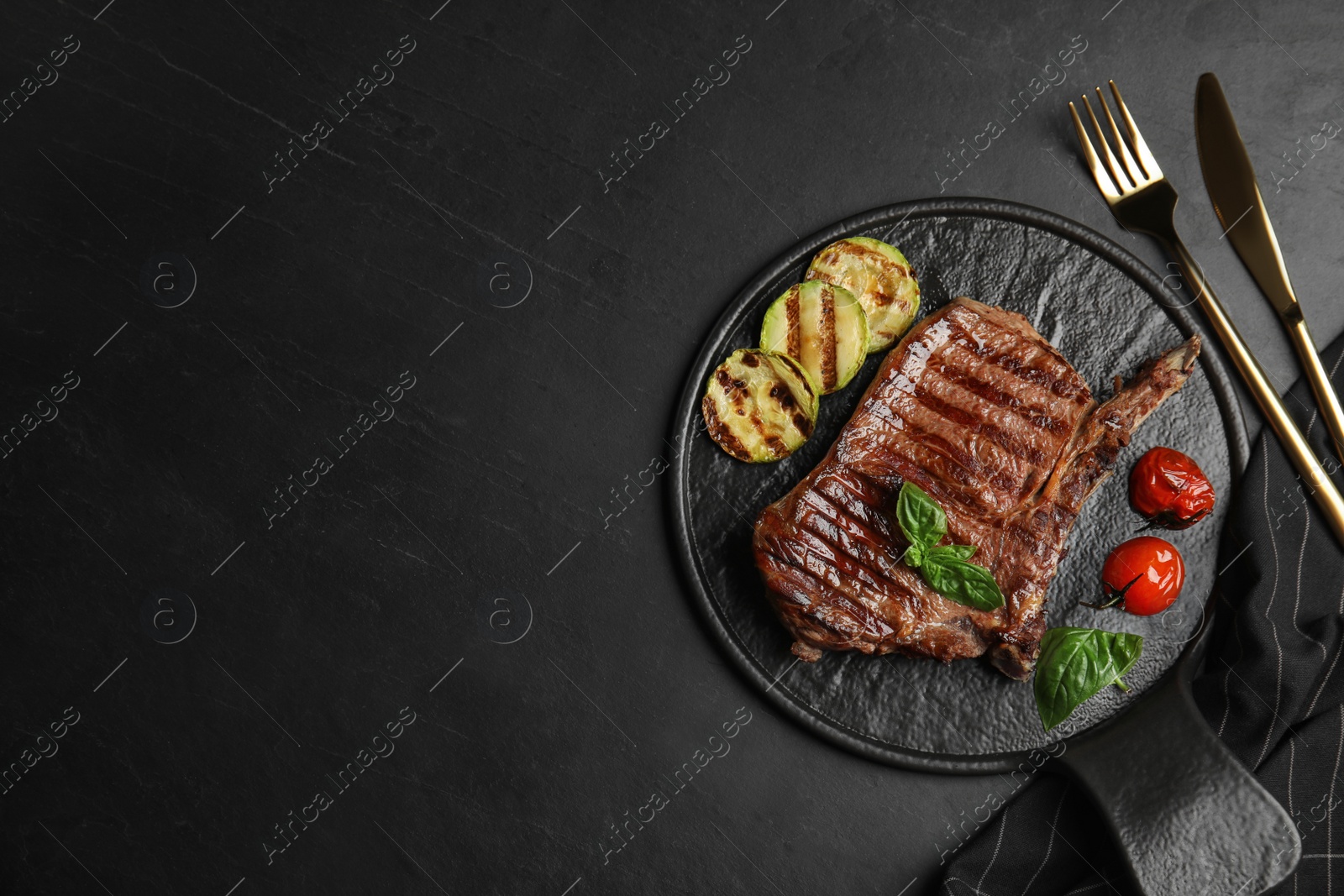 Photo of Flat lay composition with grilled meat steak on black background. Space for text