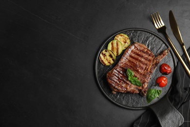 Photo of Flat lay composition with grilled meat steak on black background. Space for text