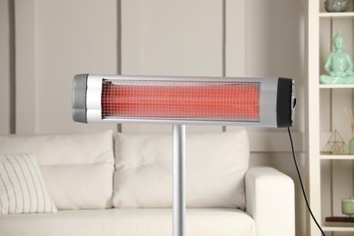 Photo of Modern electric infrared heater in cozy room