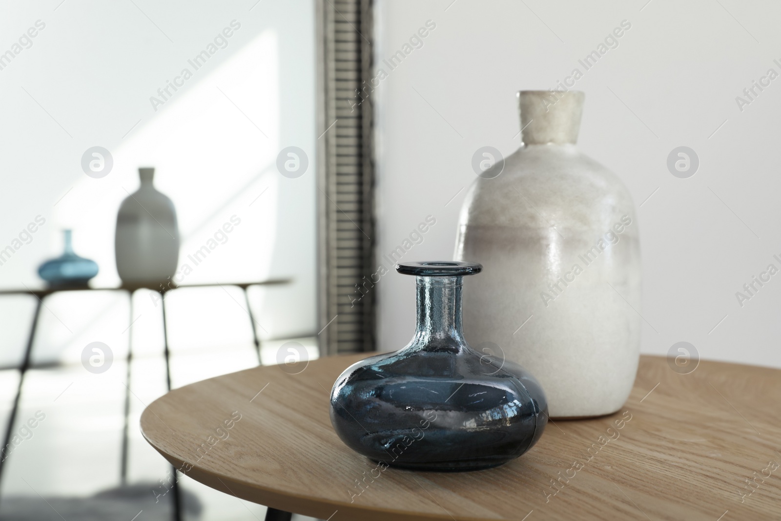 Photo of Wooden table with vases in room, closeup