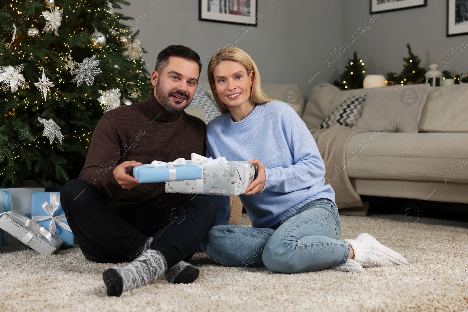 Photo of Happy couple with Christmas gifts at home