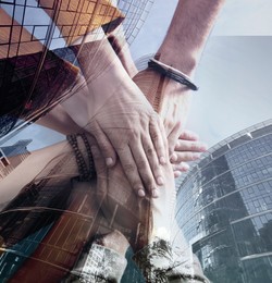 Partnership concept. Double exposure of people joining hands together and buildings