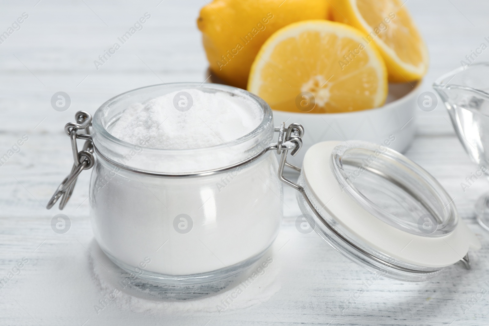 Photo of Jar with baking soda and lemons on light table