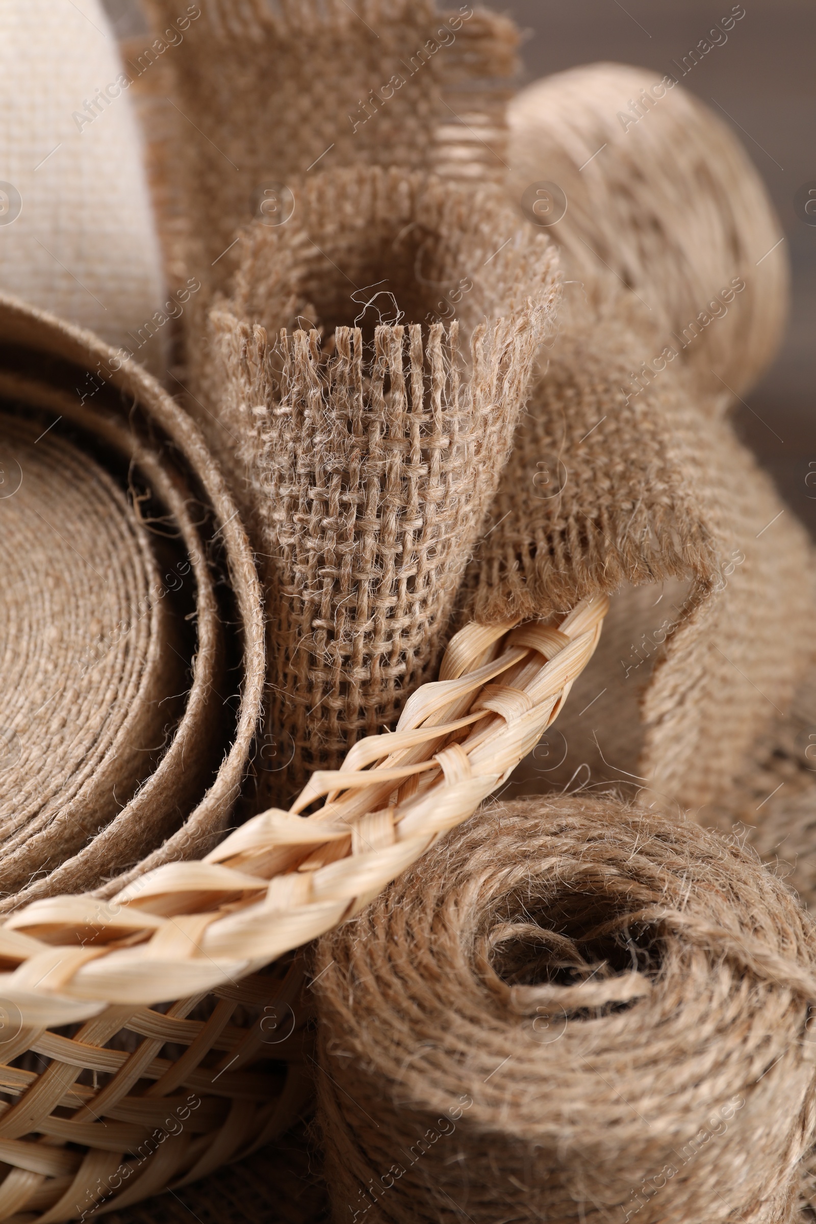 Photo of Pieces of burlap fabric and twine on table, closeup