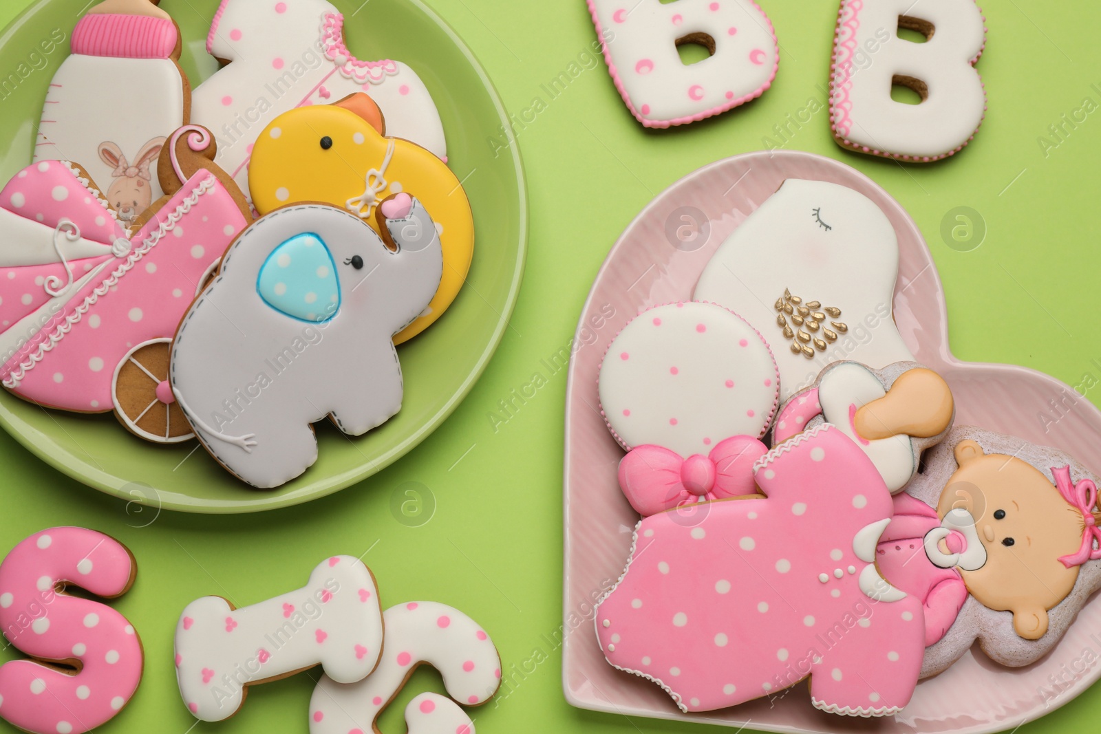 Photo of Set of baby shower cookies on light green background, flat lay