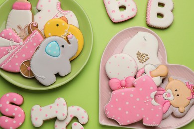 Photo of Set of baby shower cookies on light green background, flat lay