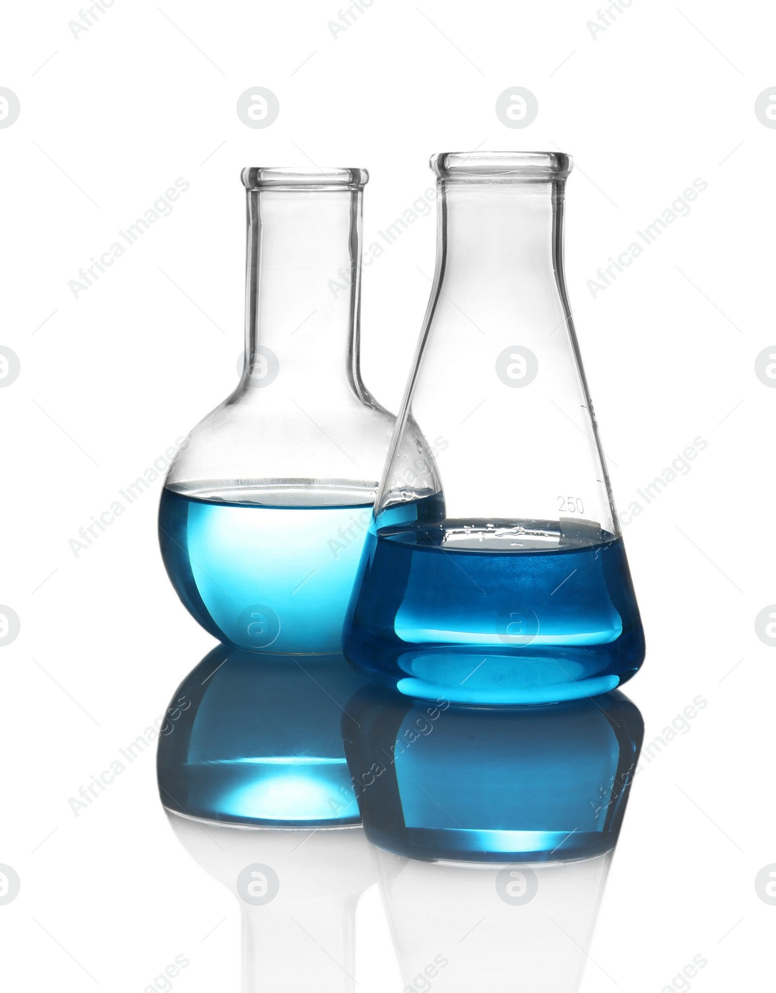 Photo of Laboratory glassware with liquid on table against white background. Chemical analysis