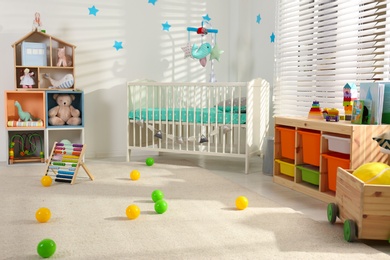 Photo of Cozy baby room interior with comfortable crib