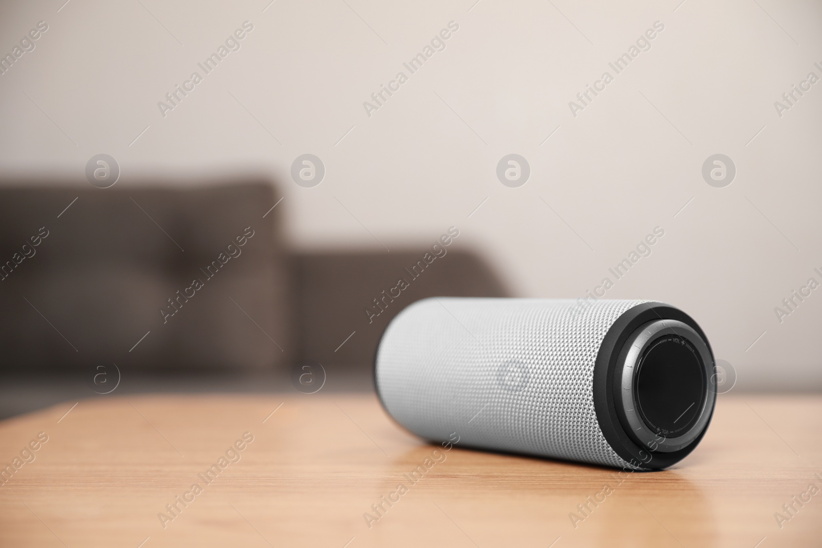 Photo of One portable bluetooth speaker on wooden table indoors, space for text. Audio equipment