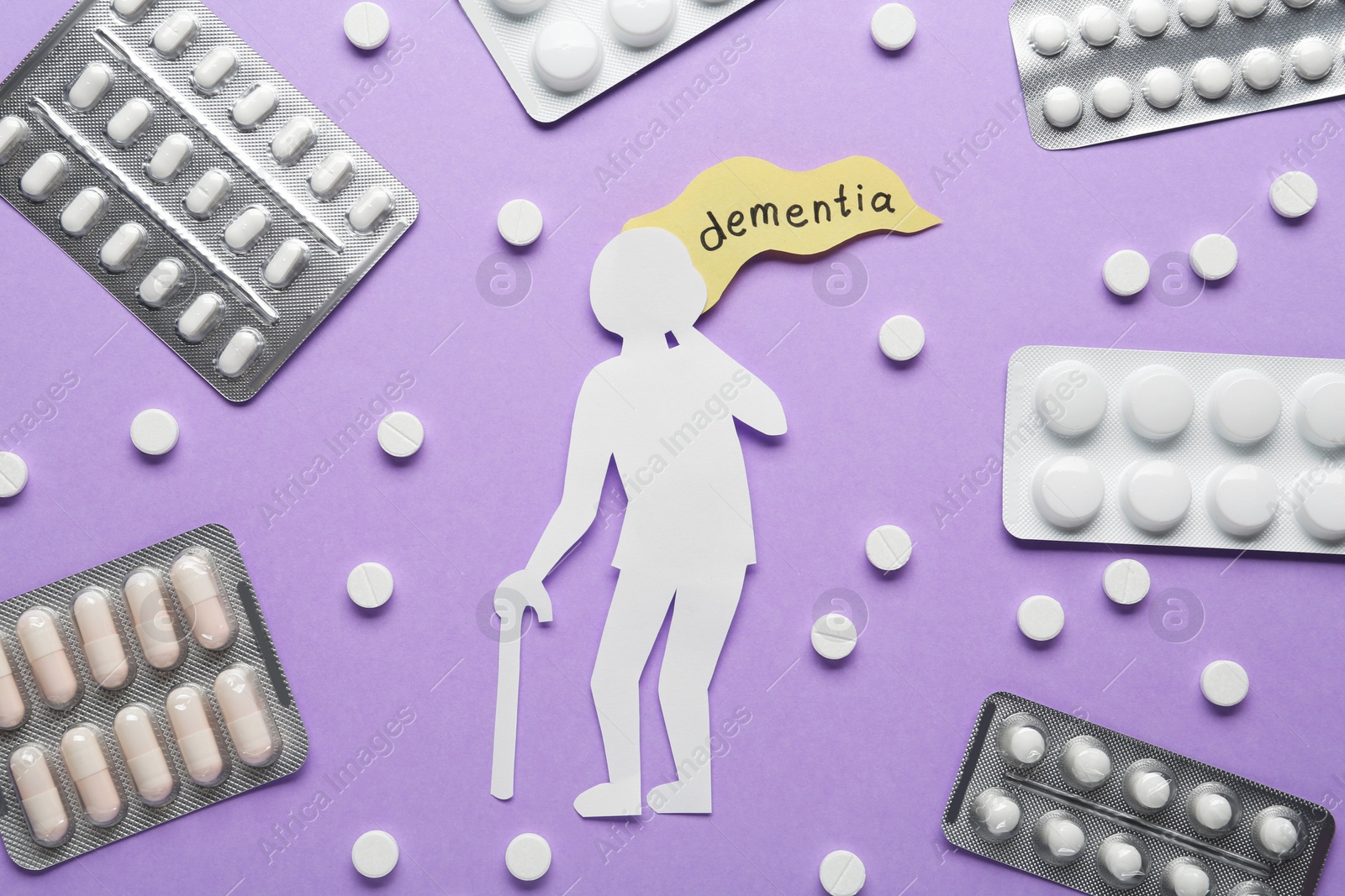 Photo of Old person paper cutout with word Dementia and pills on violet background, flat lay