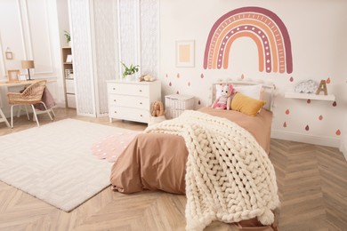 Photo of Stylish room with comfortable bed for kids. Interior design