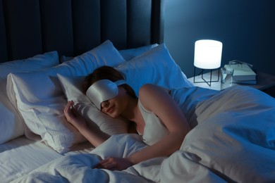 Woman with mask sleeping in bed at night