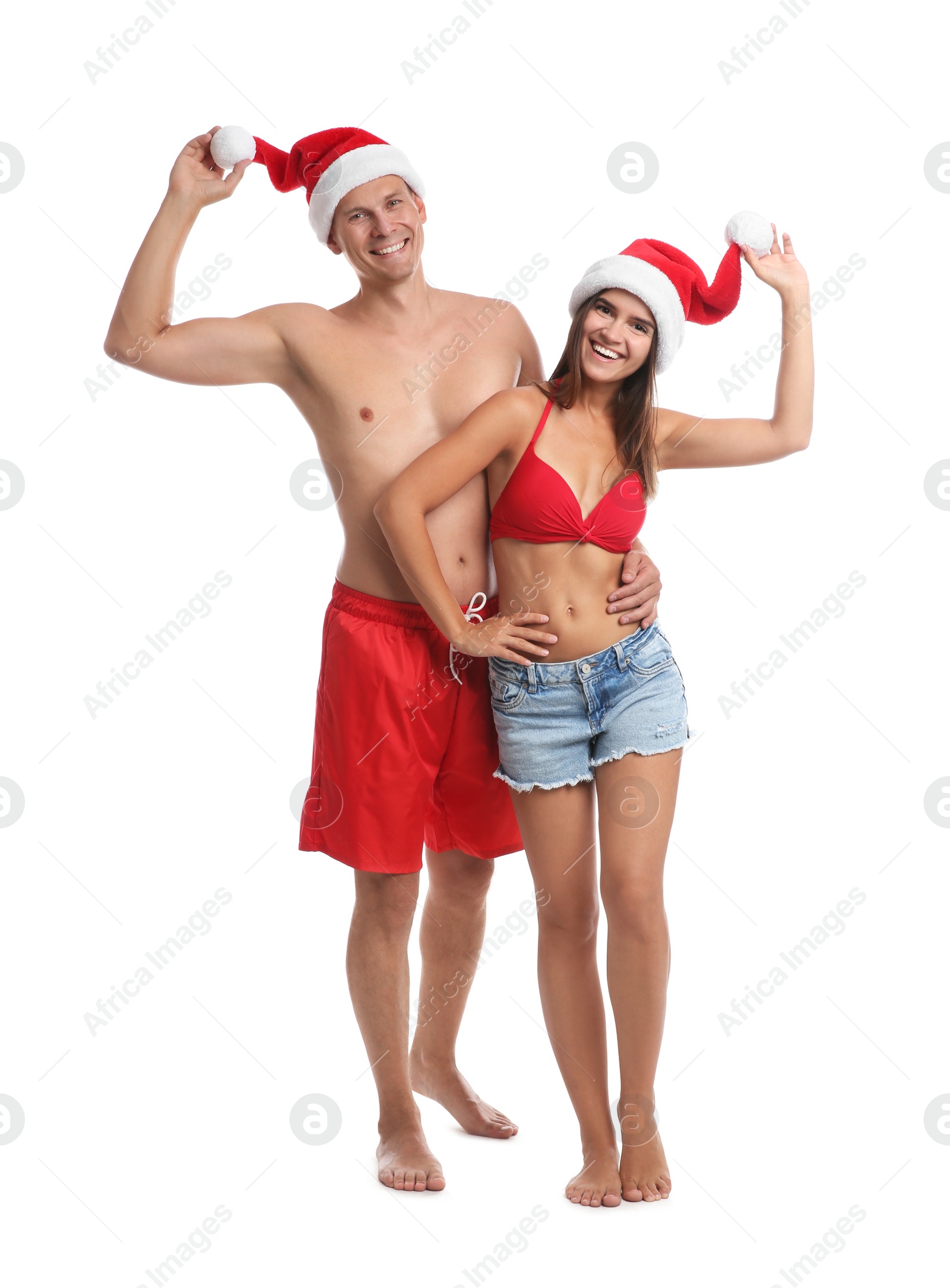 Photo of Happy couple with Santa hats together on white background. Christmas vacation