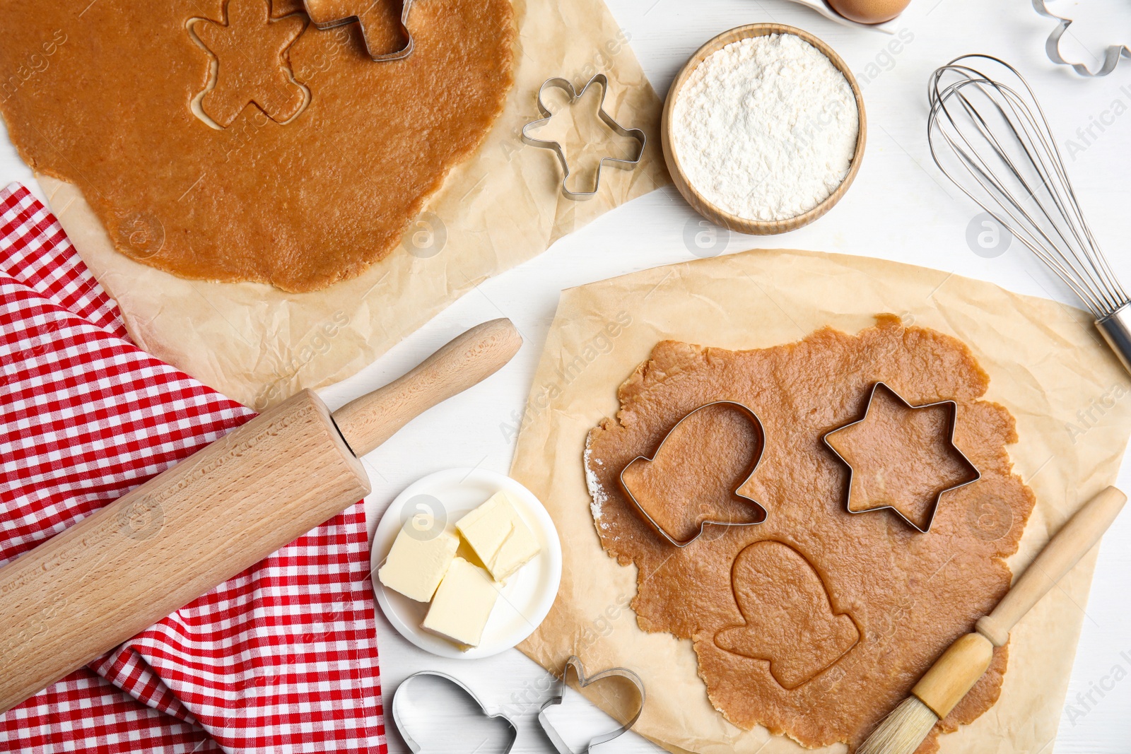 Photo of Dough, different cutters and ingredients for Christmas cookies on white wooden table, flat lay