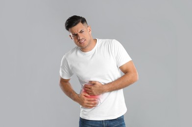 Photo of Man suffering from liver pain on grey background