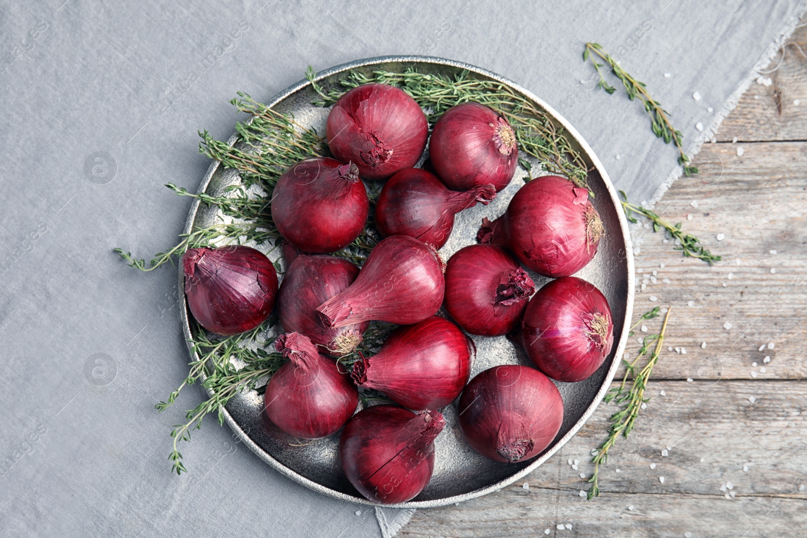 Photo of Plate with ripe red onions on table, top view