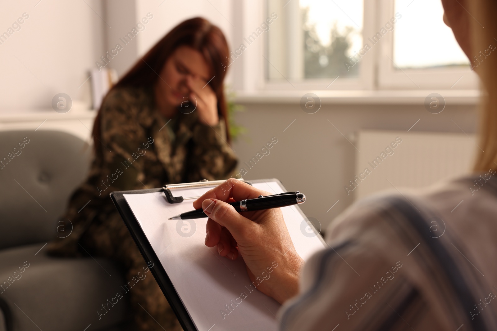 Photo of Psychologist working with military officer in office, focus on hand