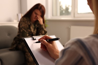 Psychologist working with military officer in office, focus on hand