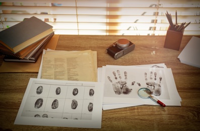 Fingerprints and papers on desk in office. Detective's workplace